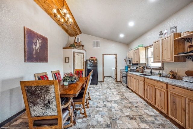 kitchen featuring light stone countertops, appliances with stainless steel finishes, sink, and lofted ceiling