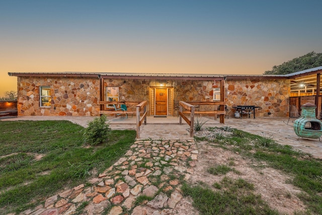 back house at dusk with a patio area