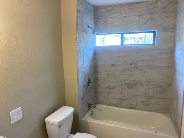 bathroom featuring tiled shower / bath and toilet