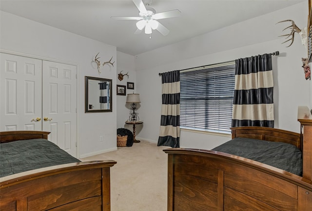 bedroom with ceiling fan, light colored carpet, and a closet