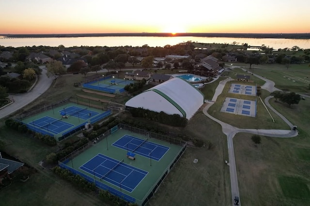 aerial view at dusk featuring a water view