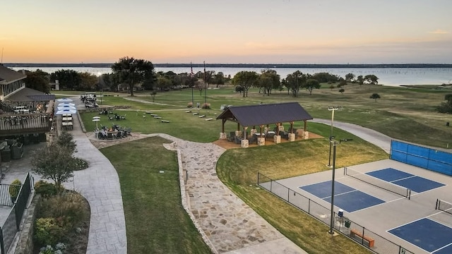 aerial view at dusk featuring a water view