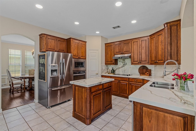 kitchen featuring a kitchen island, appliances with stainless steel finishes, tasteful backsplash, sink, and light tile patterned floors