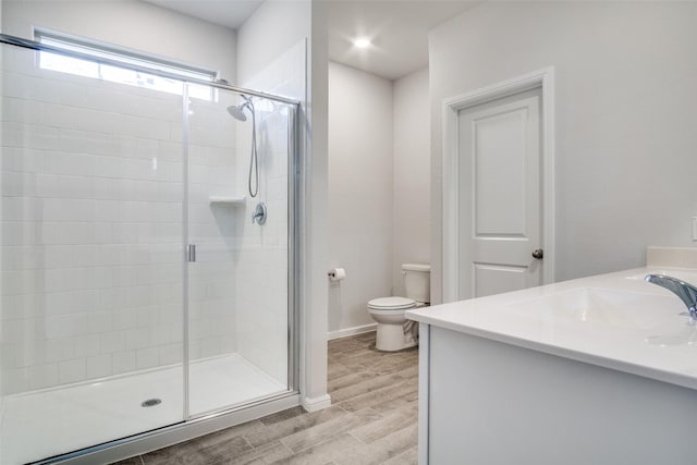 bathroom featuring vanity, an enclosed shower, wood-type flooring, and toilet