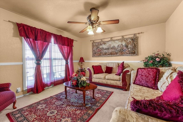 carpeted living room featuring a ceiling fan and a textured ceiling