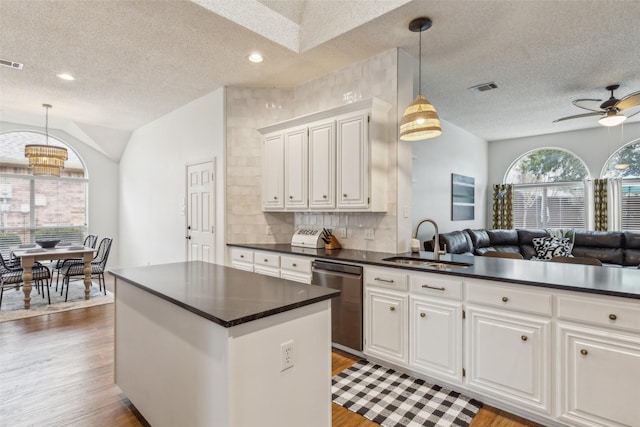 kitchen with white cabinetry, dark wood-type flooring, dishwasher, and sink