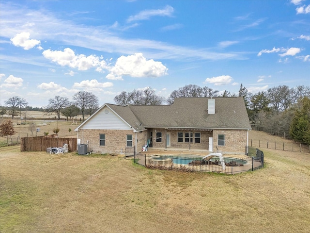 back of property with a fenced in pool, a lawn, central air condition unit, and a patio area