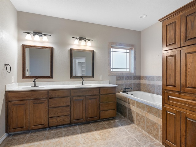 bathroom with a relaxing tiled tub, vanity, and tile patterned flooring