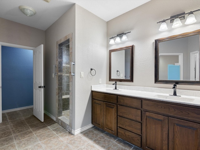 bathroom featuring a tile shower, vanity, and tile patterned floors