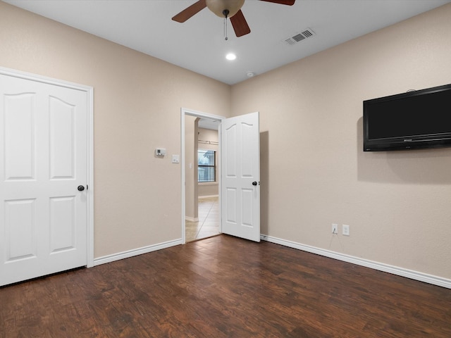 unfurnished bedroom featuring ceiling fan and dark hardwood / wood-style flooring