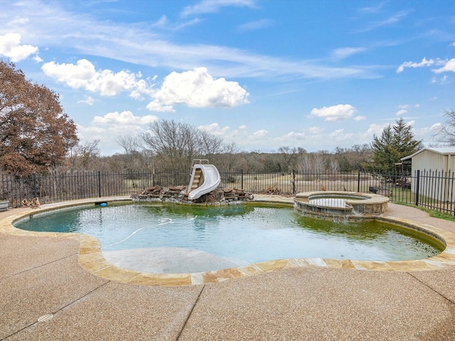 view of pool featuring an in ground hot tub, a water slide, and a patio area