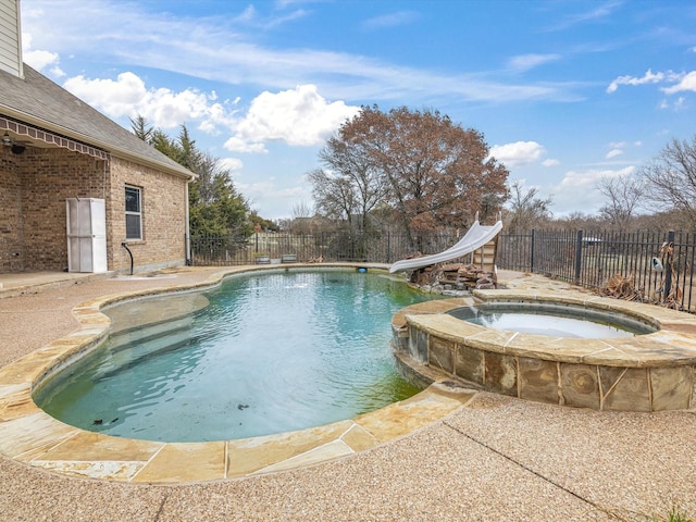 view of swimming pool featuring an in ground hot tub, a water slide, and a patio area