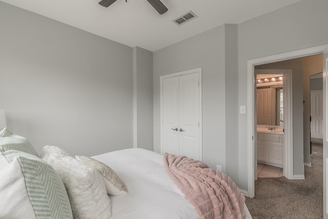 bedroom featuring ceiling fan, light colored carpet, sink, and a closet