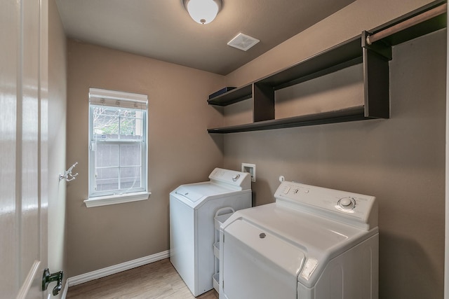 laundry room featuring washing machine and clothes dryer and light wood-type flooring