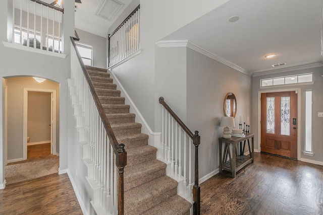 foyer with crown molding, a healthy amount of sunlight, and dark hardwood / wood-style floors