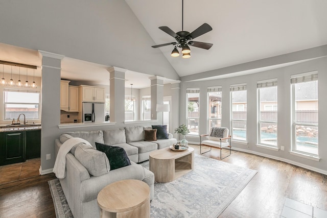 living room with sink, ceiling fan, a healthy amount of sunlight, and ornate columns