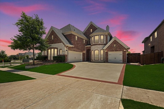 french country style house featuring brick siding, a front lawn, fence, concrete driveway, and an attached garage