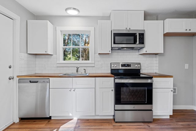 kitchen featuring wood counters, appliances with stainless steel finishes, sink, and white cabinets