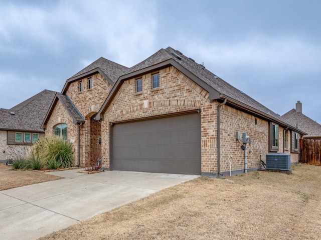 view of front of property with central AC unit and a garage