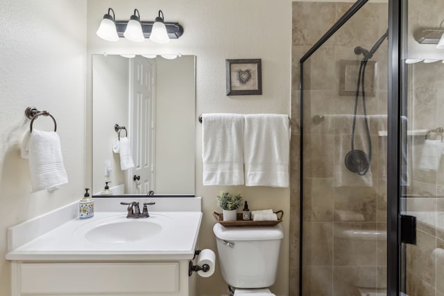 full bath featuring a stall shower, vanity, and toilet