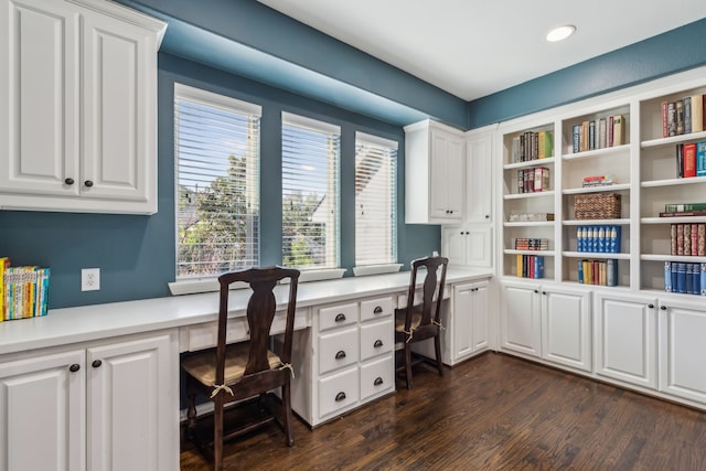 home office with dark wood-style floors, built in desk, and recessed lighting