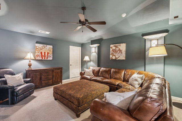 living room with ceiling fan, visible vents, and light colored carpet