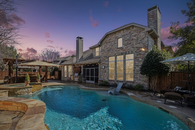 rear view of house featuring a patio area, brick siding, fence, and a chimney