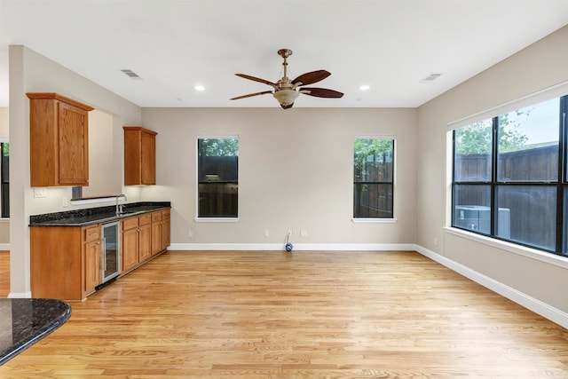 6039 Reiger Ave, Dallas, TX 75214 - kitchen featuring wine cooler, visible vents, brown cabinetry, a sink, and light wood-style flooring