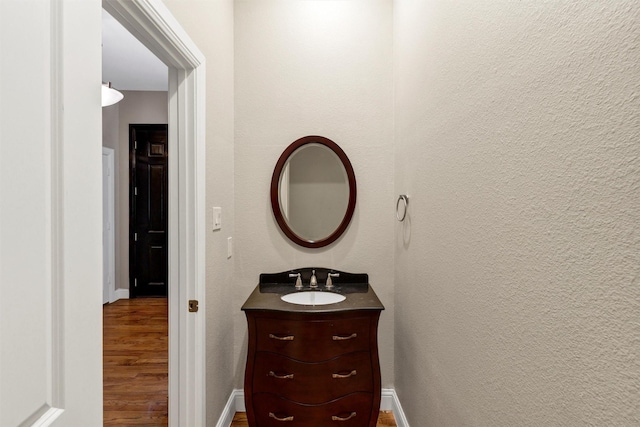6039 Reiger Ave, Dallas, TX 75214 - bathroom with baseboards, vanity, and wood finished floors
