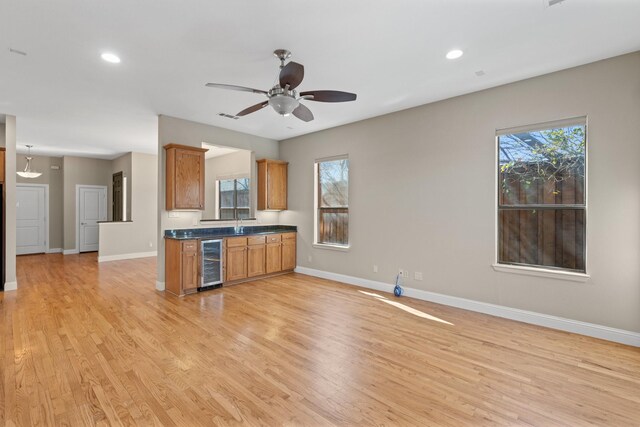 kitchen with beverage cooler, visible vents, appliances with stainless steel finishes, ventilation hood, and brown cabinets