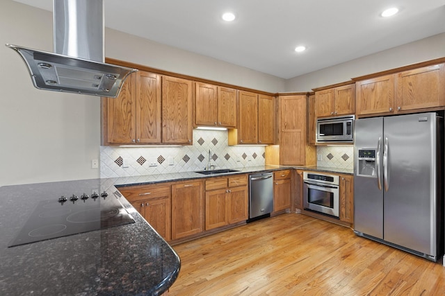 6039 Reiger Ave, Dallas, TX 75214 - kitchen featuring dark stone counters, a sink, brown cabinets, island exhaust hood, and appliances with stainless steel finishes