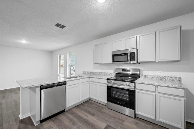 kitchen featuring stainless steel appliances, white cabinetry, sink, and kitchen peninsula