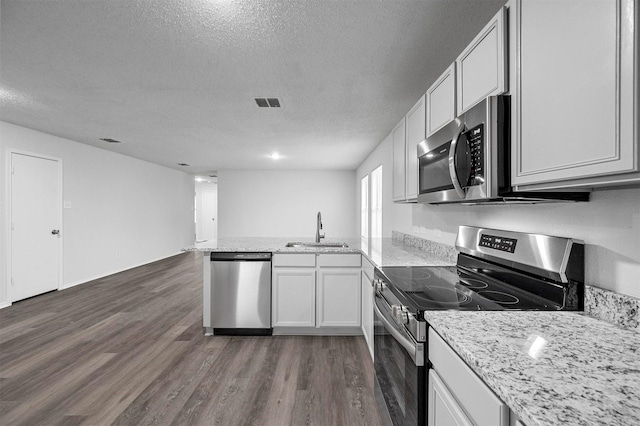 kitchen featuring sink, kitchen peninsula, white cabinets, and appliances with stainless steel finishes