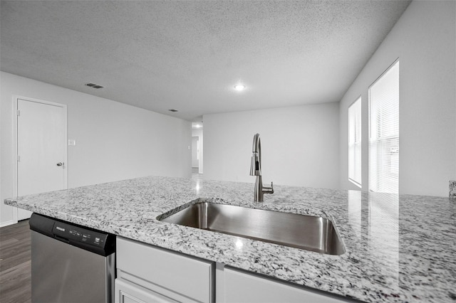 kitchen with sink, light stone counters, stainless steel dishwasher, dark hardwood / wood-style floors, and white cabinets