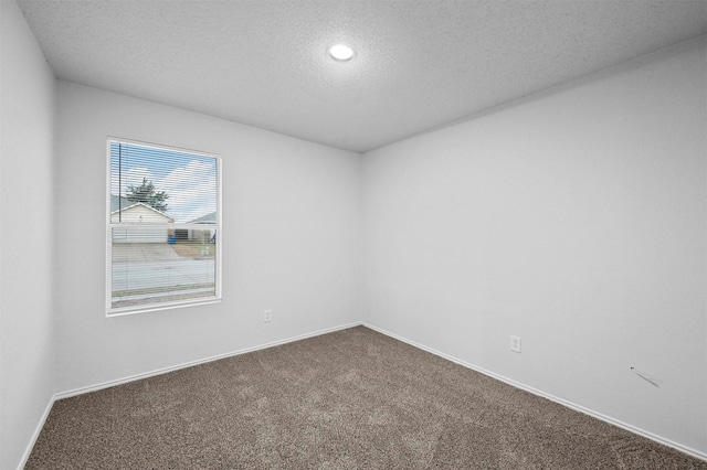 unfurnished room with carpet flooring and a textured ceiling