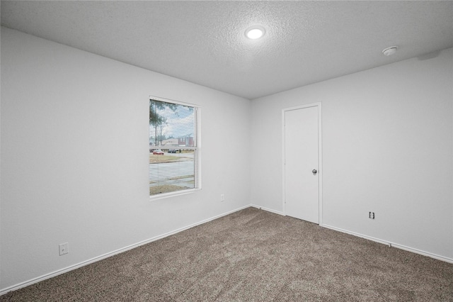 carpeted spare room featuring a textured ceiling