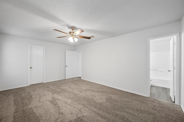 unfurnished bedroom featuring ceiling fan, carpet floors, a textured ceiling, and ensuite bathroom