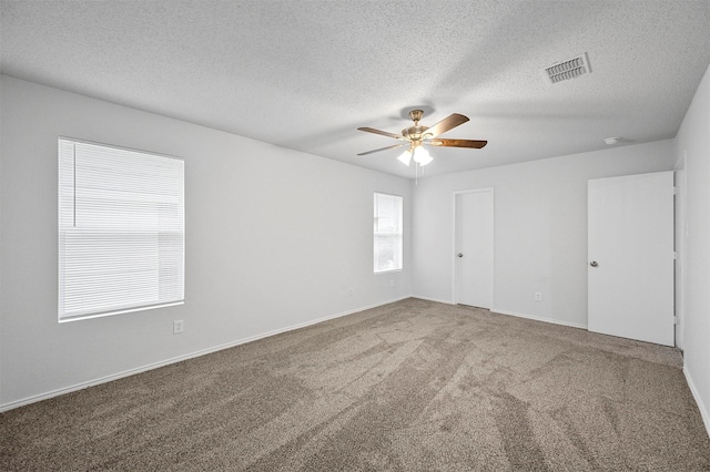 empty room with carpet, a textured ceiling, and ceiling fan