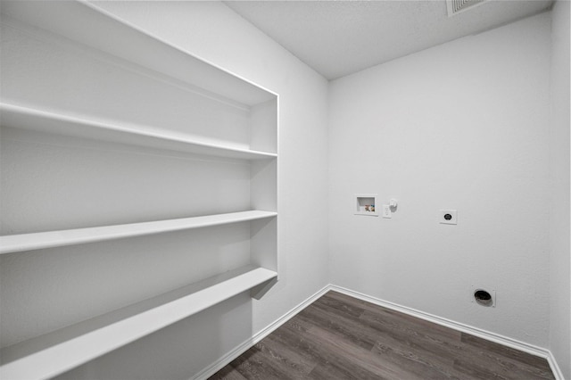 clothes washing area with dark hardwood / wood-style flooring, hookup for a gas dryer, hookup for a washing machine, and electric dryer hookup