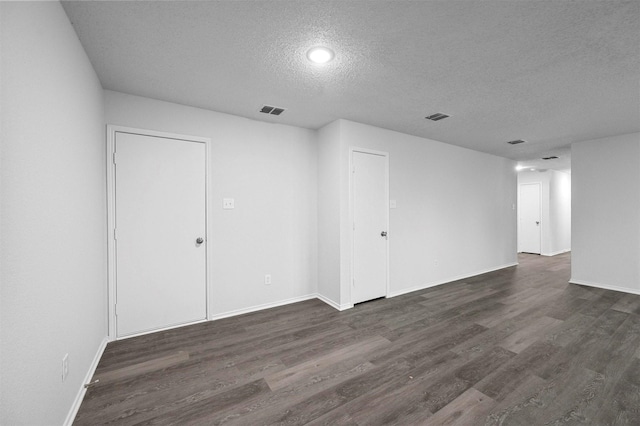 unfurnished room with dark hardwood / wood-style flooring and a textured ceiling