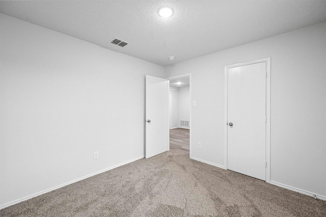 unfurnished bedroom with carpet flooring and a textured ceiling