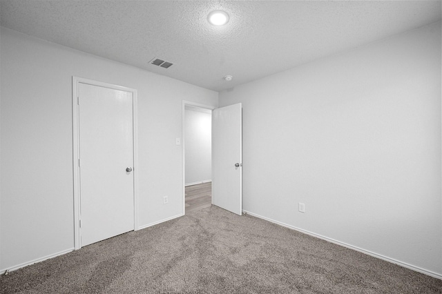 unfurnished bedroom with carpet floors and a textured ceiling