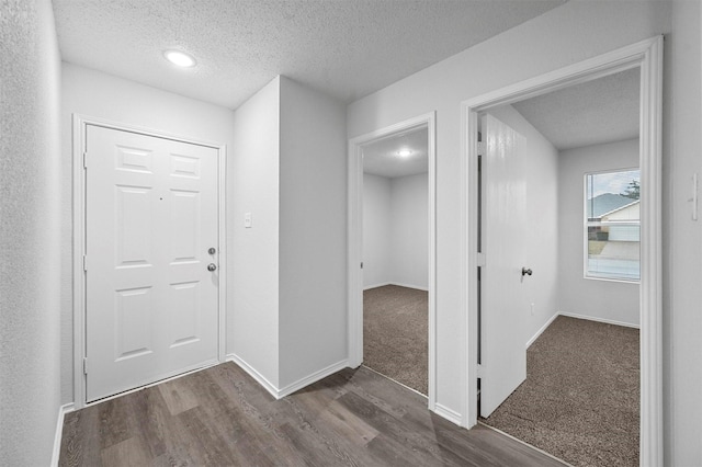 entryway with dark hardwood / wood-style flooring and a textured ceiling