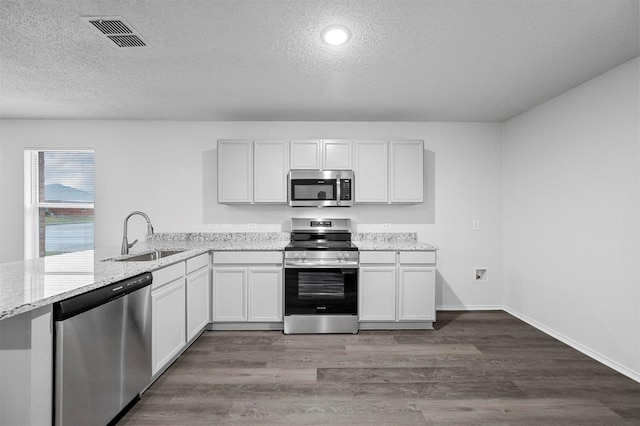 kitchen with stainless steel appliances, white cabinetry, and sink