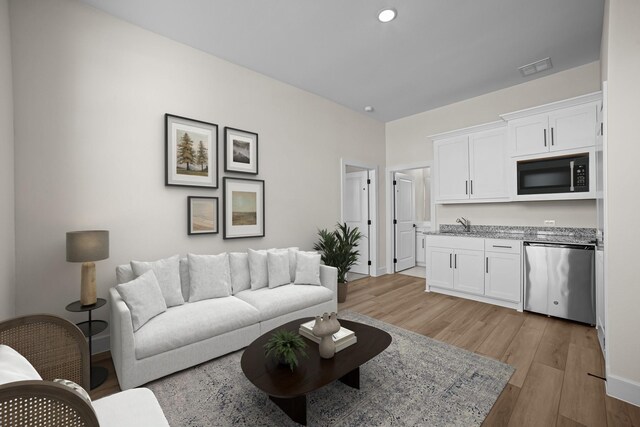 living area with light wood finished floors, baseboards, and visible vents