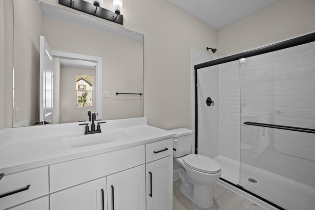 bathroom with toilet, vanity, tile patterned floors, and a stall shower