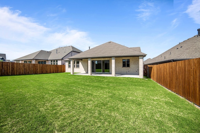 rear view of property featuring a fenced backyard, brick siding, a patio area, and a lawn