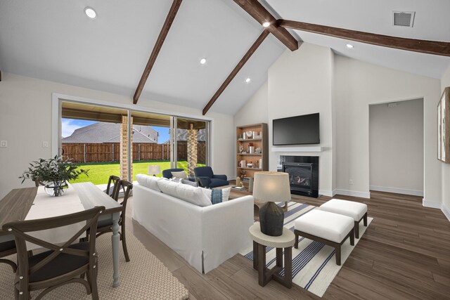 living room featuring high vaulted ceiling, wood finished floors, baseboards, beam ceiling, and visible vents