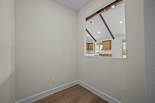 spare room with baseboards, vaulted ceiling with beams, dark wood-style floors, and recessed lighting