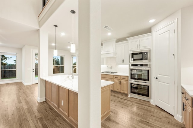 1130 Cardinal Dr, Midlothian, TX 76065 - kitchen with appliances with stainless steel finishes, light wood finished floors, decorative light fixtures, premium range hood, and recessed lighting